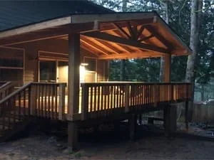 Elevated wooden deck with timber pergola overhead structure and integrated lighting