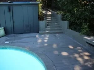Finished concrete patio with pool surround, dappled shade from trees