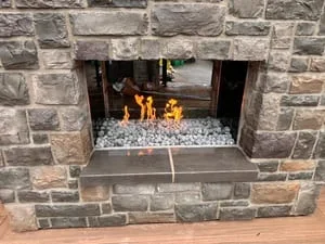 Stone fireplace with stacked veneer and glass bead fire feature