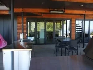 Interior remodel with wood ceiling, black-framed glass doors, and open dining area
