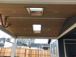 Wood-framed covered patio with two skylights and recessed lighting installed
