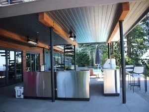 Covered patio with exposed beams, metal roof, concrete floor, and glass doors